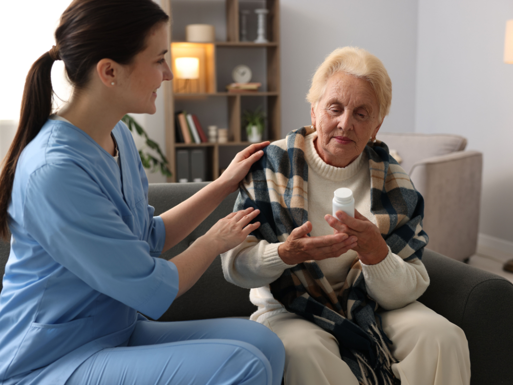 Support worker assisting an older participant with medication and daily care at home